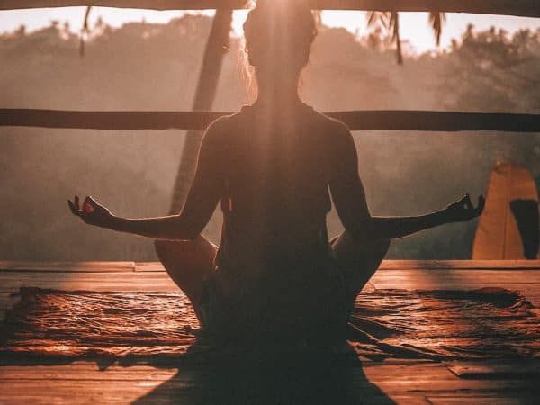 woman doing yoga meditation on brown parquet flooring